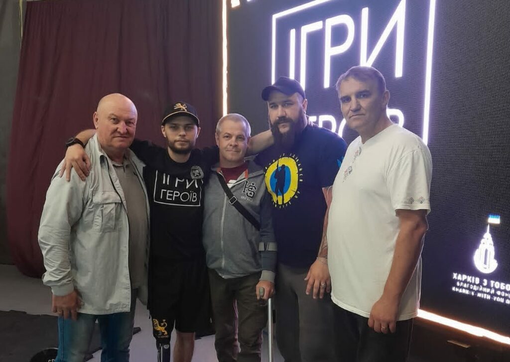 П'ятеро чоловік різних вікових груп стоять разом із підтримкою єдності та спільної мети.