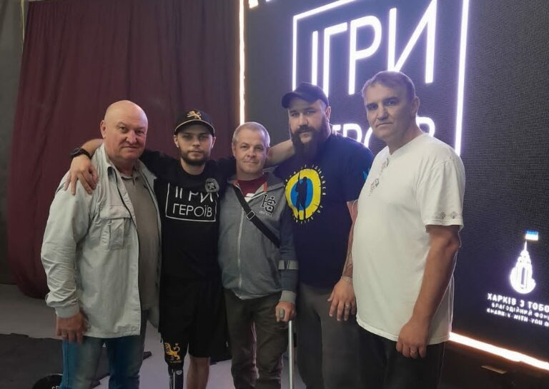 П'ятеро чоловік різних вікових груп стоять разом із підтримкою єдності та спільної мети.