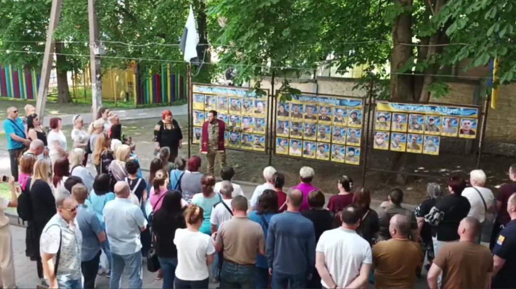 Натовп людей зібрався біля імпровізованої виставки, присвяченої учасникам російсько-української війни.
