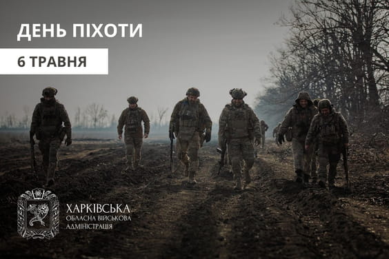 Військовослужбовці у камуфляжі та шоломах прямують по дорозі до місця призначення, на тлі сірої деревної рослинності та вологого ґрунту.