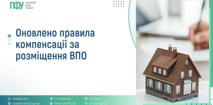 Коричневий будинок із сірим фундаментом та білими віконними рамами на столі поряд із людиною, що працює з документами.