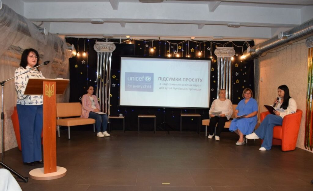 Жінка виступає за трибуною на заході UNICEF, присвяченому підсумкам проєкту з надовлення освітніх втрат для дітей Чугуївської громади.