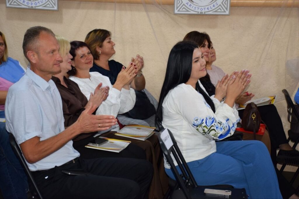 Учасники заходу сидять на стіль