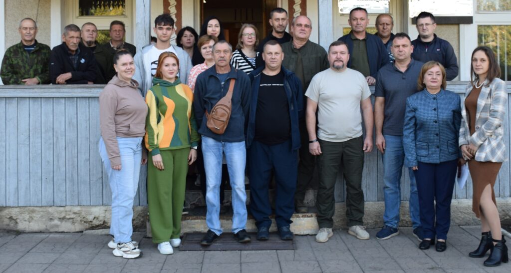 Група людей різного віку стоїть на сходах перед будівлею, утворюючи спільну групу.
