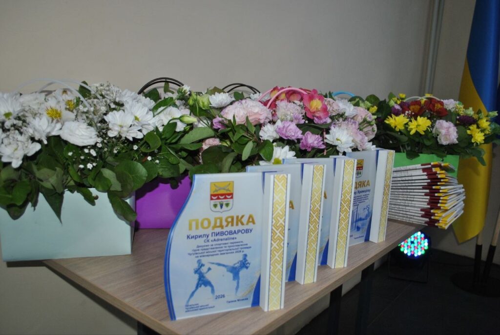На столі розташовані букети квітів та подячні грамоти з написом «ПОДЯКА Кирилу ПИВОВАРОВУ».
